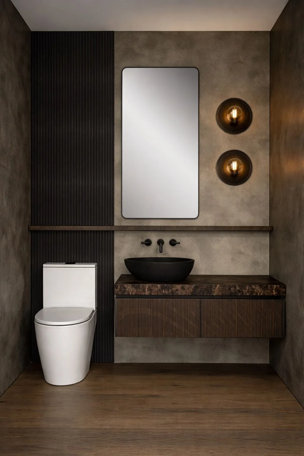 Modern bathroom with a white toilet, a black vessel sink on a dark wood vanity, and two black wall-mounted sconces with filament bulbs, a mirror, and textured walls.