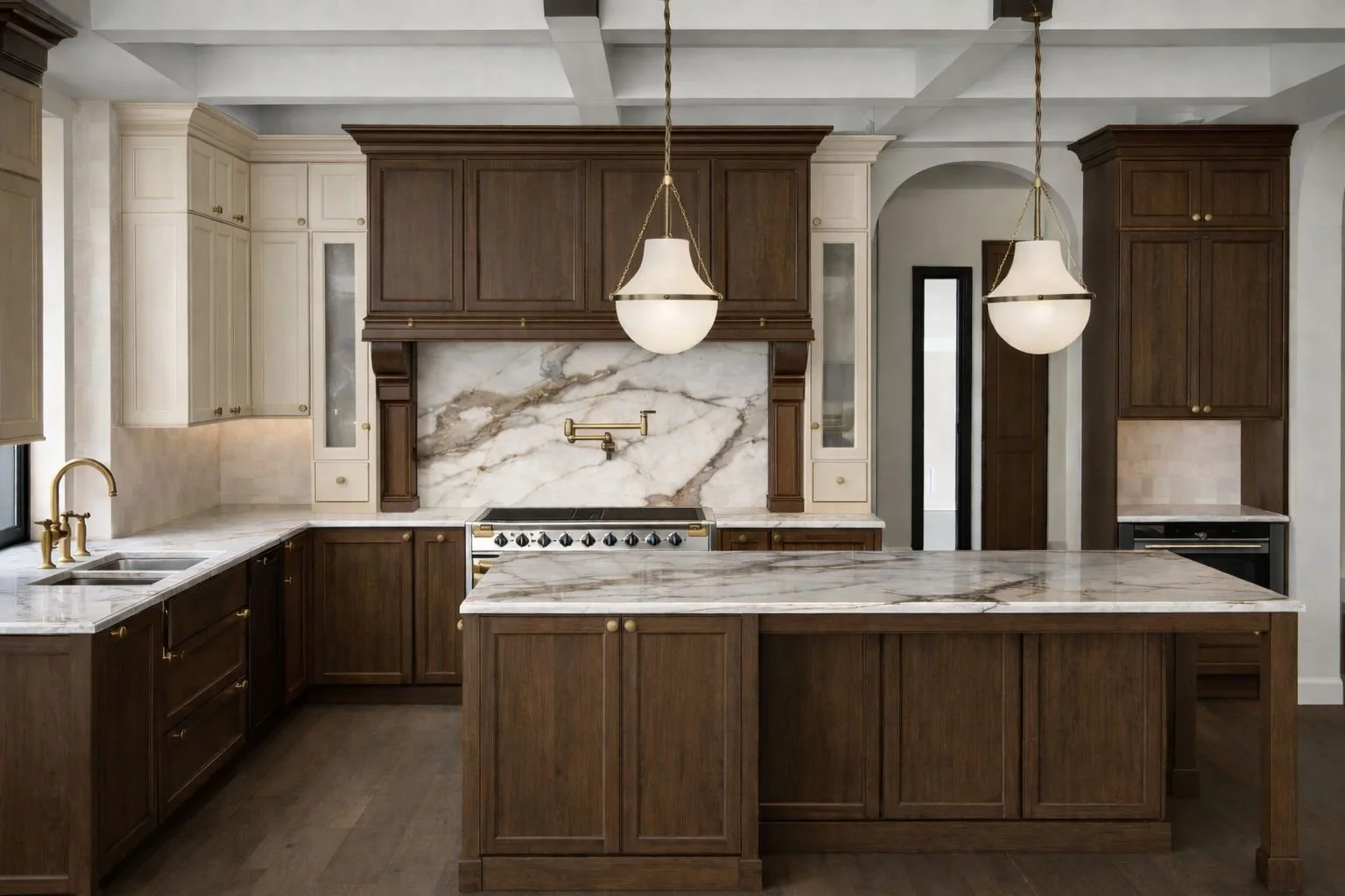 Modern kitchen featuring dark wooden cabinets, white marble countertops, a marble backsplash, and a kitchen island with a marble top. There are two hanging pendant lights and a brass faucet over a double sink.