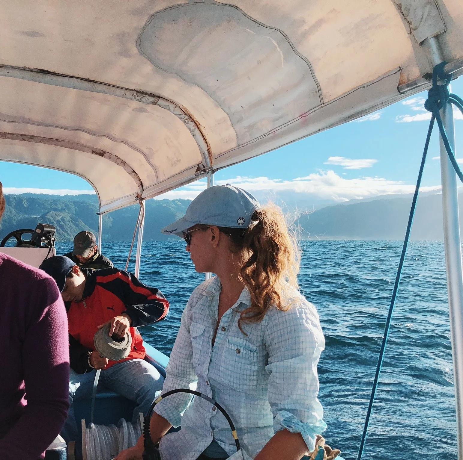 Fieldwork on a small boat on Lake Atitlán, Guatemala, mountains in the background.