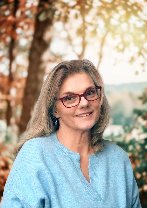 Portrait of Massachusetts Licensed Clinical Psychologist Dr. Lisa Scharff in nature wearing a blue sweater.