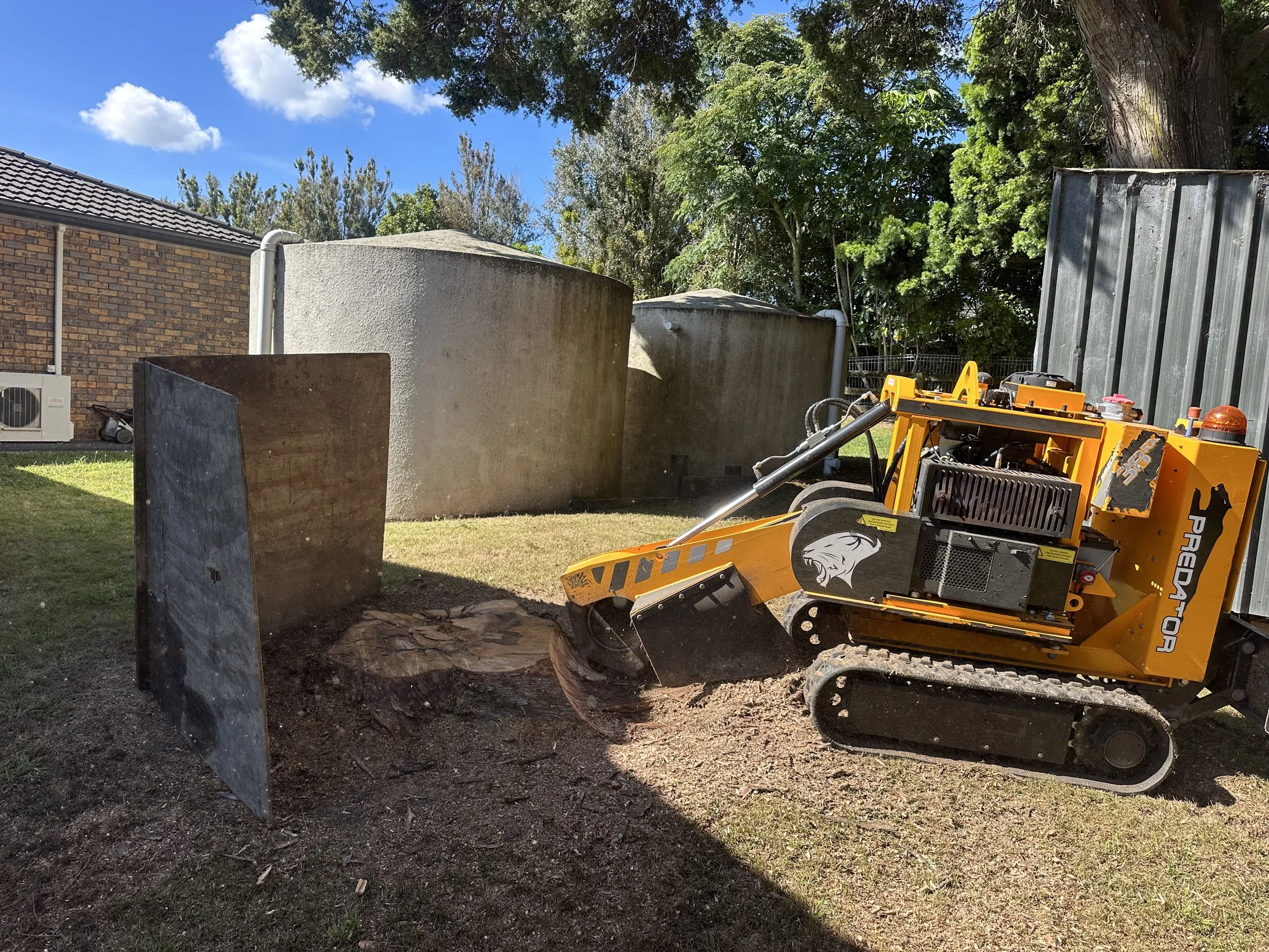 A small orange compact track stump grinder.