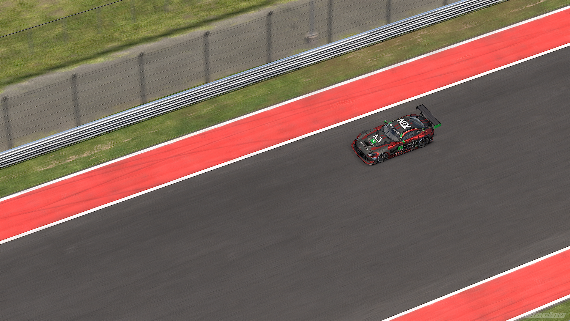 An Audi racing car on a race track, viewed from above, with a brick wall, metal fence, and grass in the background.