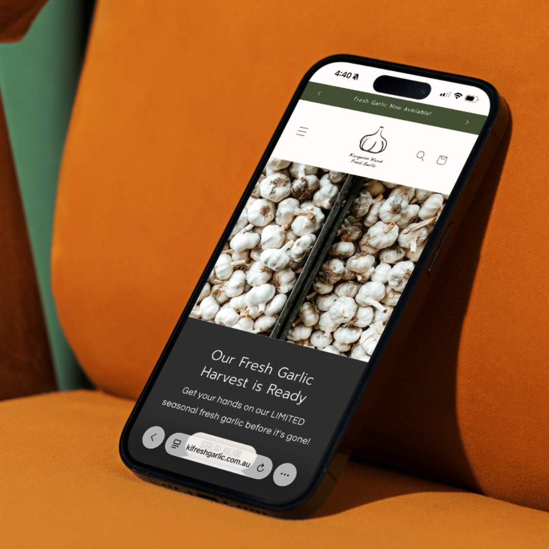 Smartphone displaying a website about fresh garlic on an orange chair.