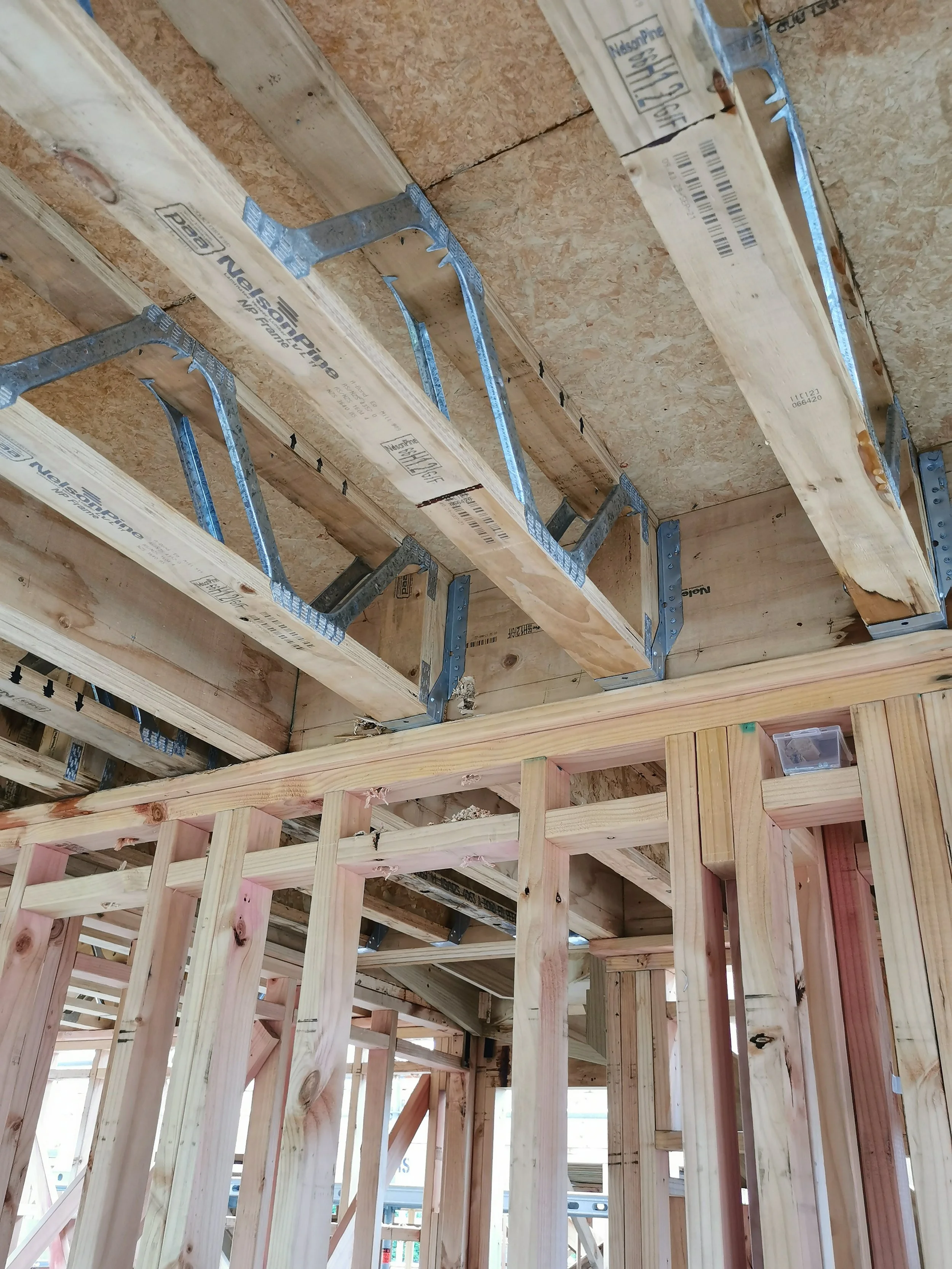 Construction site showing wooden framing and metal supports for the ceiling, with exposed beams and unfinished walls.