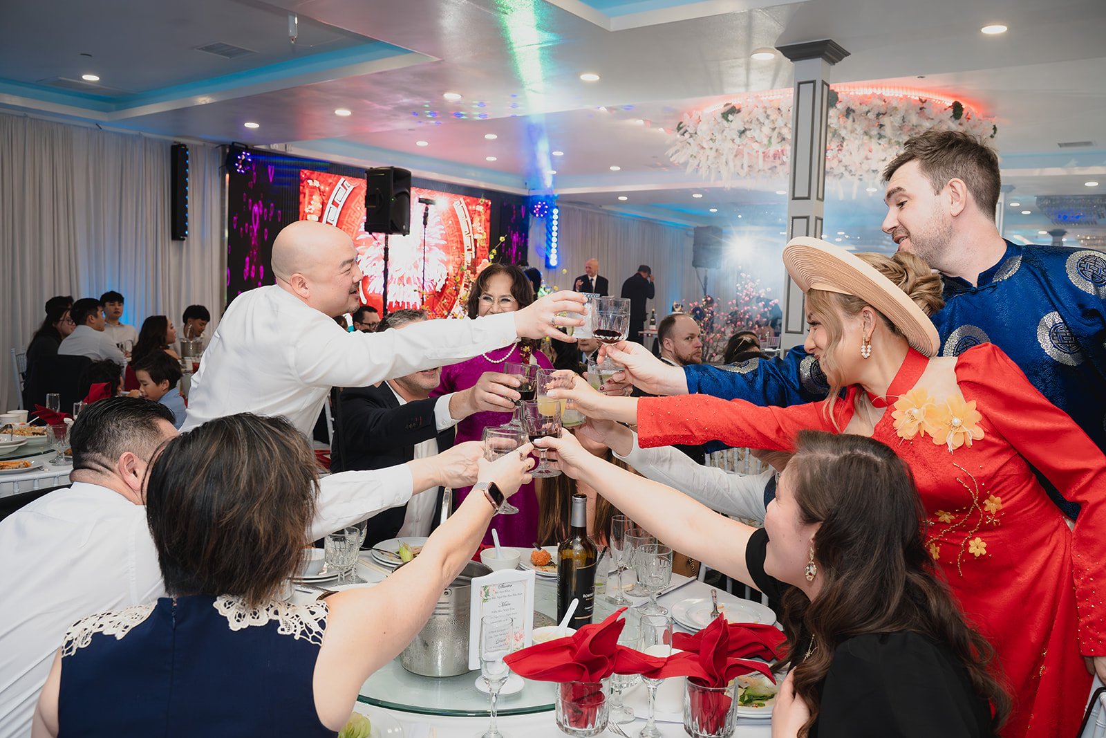 People at a banquet table raising glasses in a toast at a celebration event.
