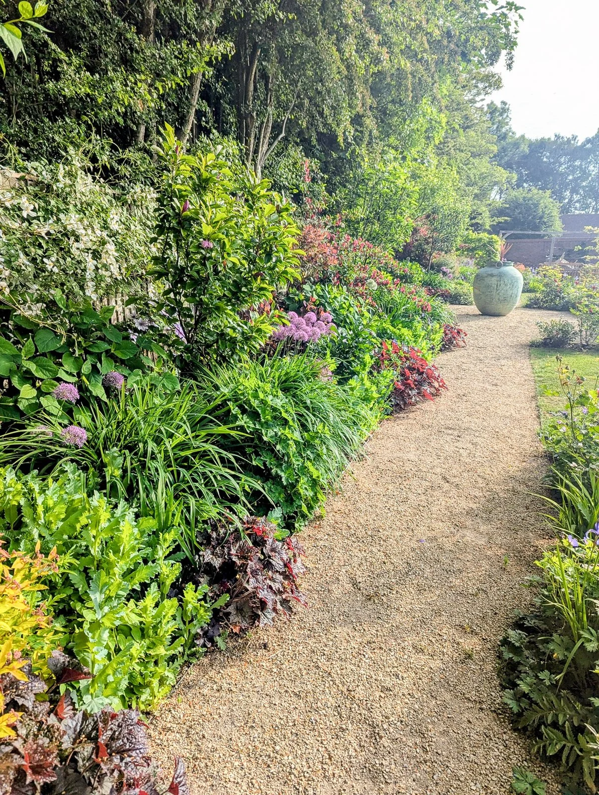 Mixed border with masses of perennials in full bloom 