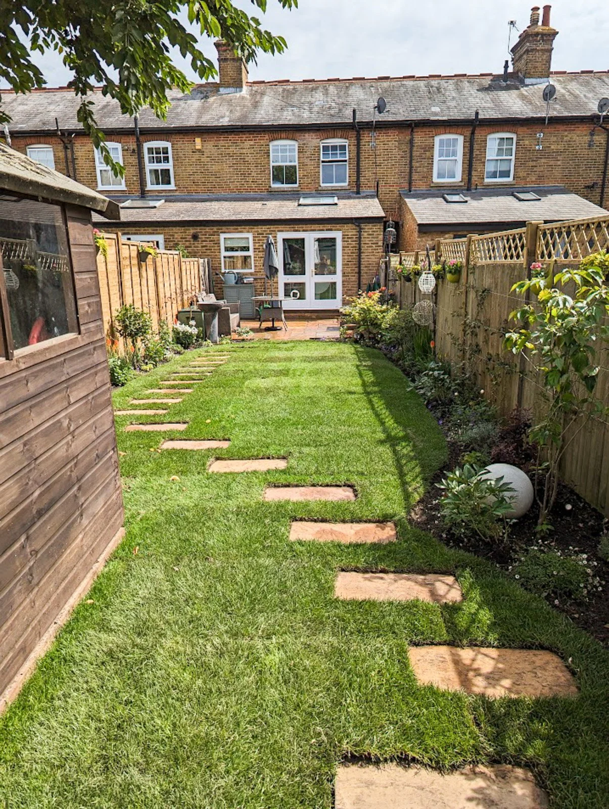 Newly installed stepping stones, turf and borders give this small garden interest in Taplow