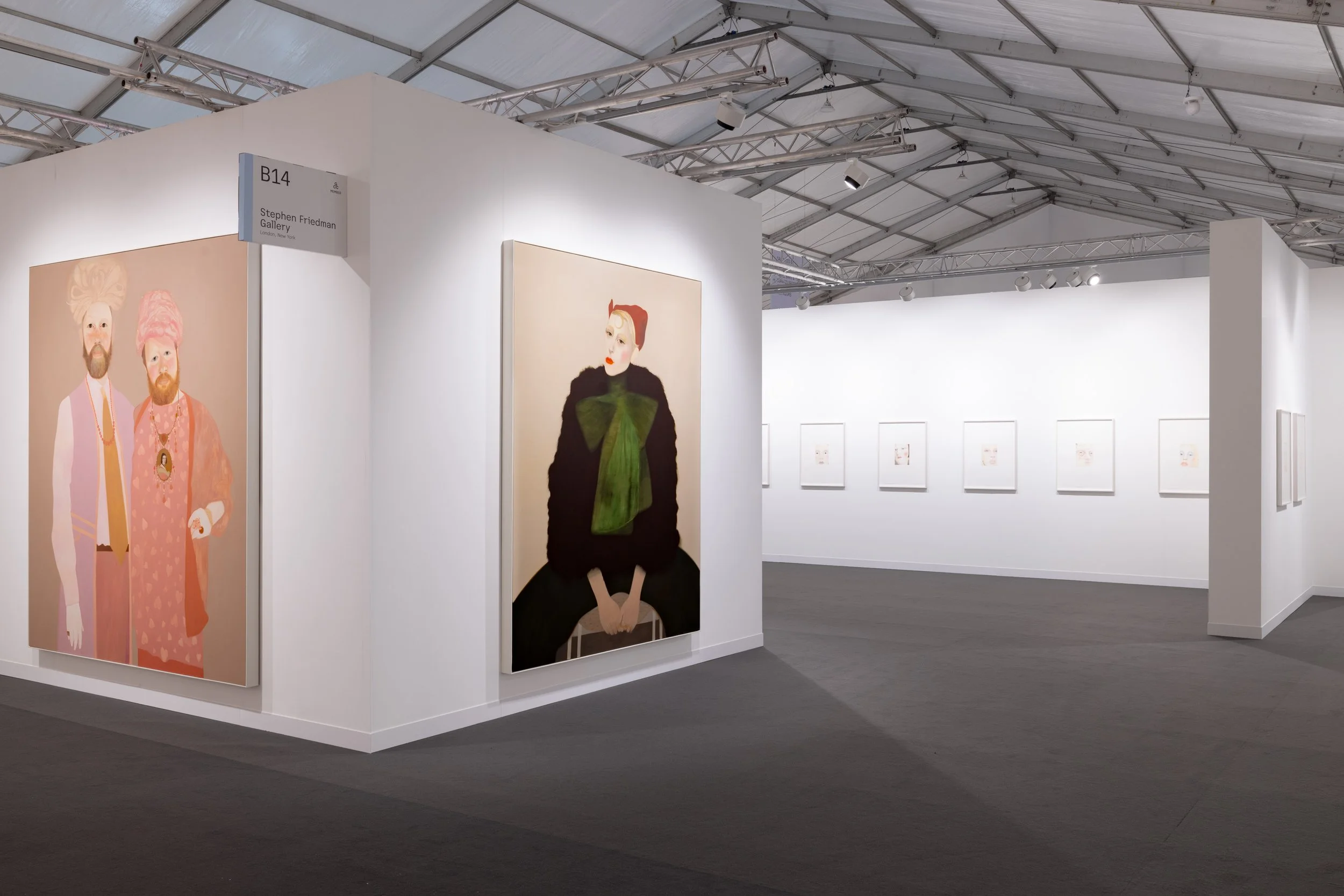 Art fair booth at Frieze London with paintings and drawings hung on white walls, including two portraits of individuals in colourful attire and a woman with blonde hair and a green bow. Sign indicating the booth as Stephen Friedman Gallery.