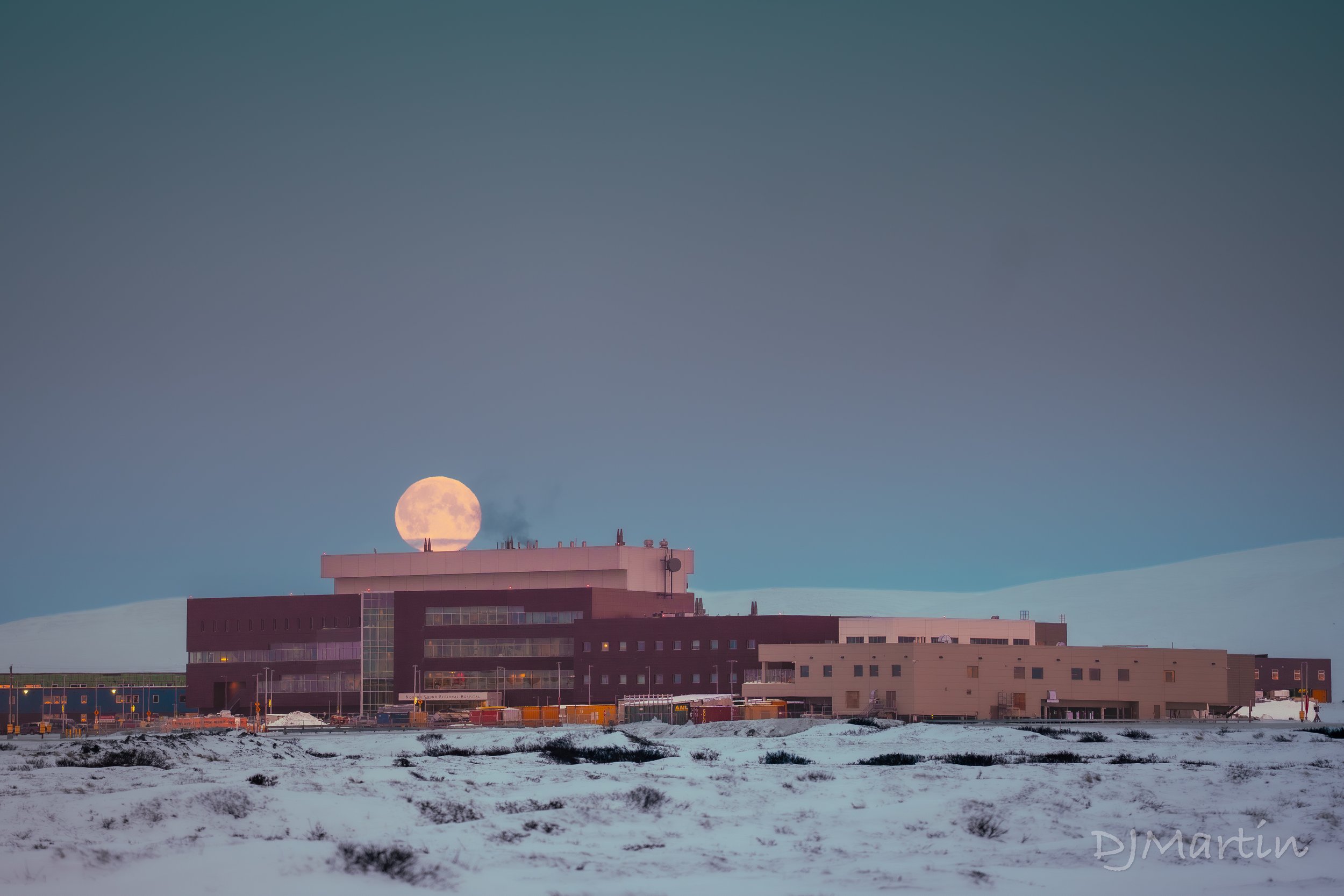 Winter moon-set over the Norton Sound Regional Health Corporation in Nome during the Arctic blue hour.
