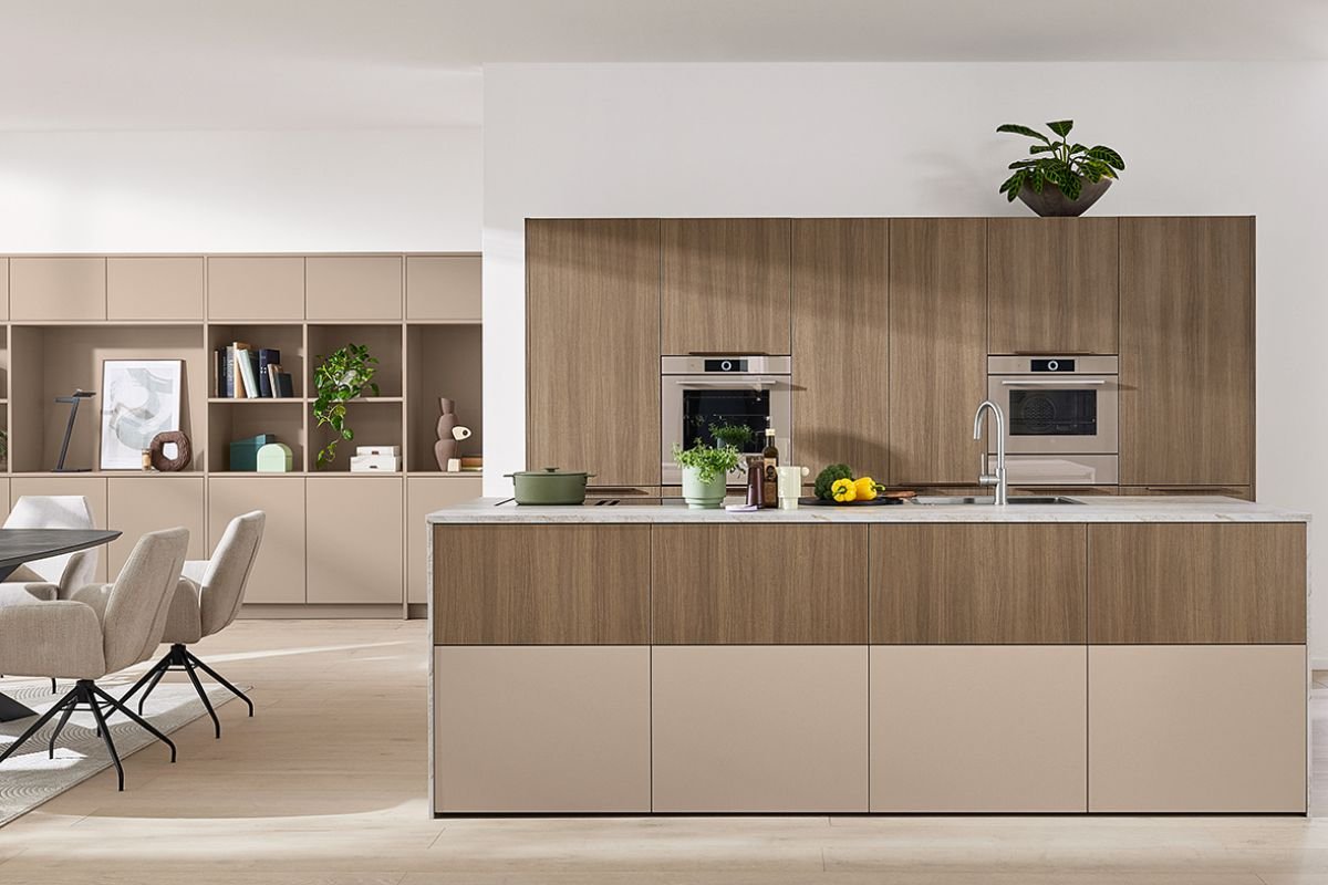 Modern kitchen with wooden cabinets, built-in ovens, a white countertop, and a potted plant on top of the cabinets.