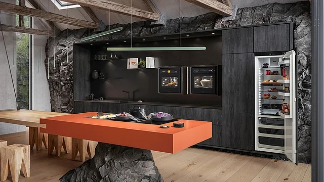 Modern kitchen with dark cabinets, built-in ovens, a fridge with glass door, an orange countertop, and a dining table with wooden stools