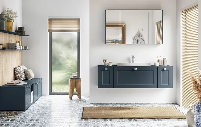 Bathroom with navy blue cabinets, a mirror, and a sink, with a door leading outside and a window with blinds.
