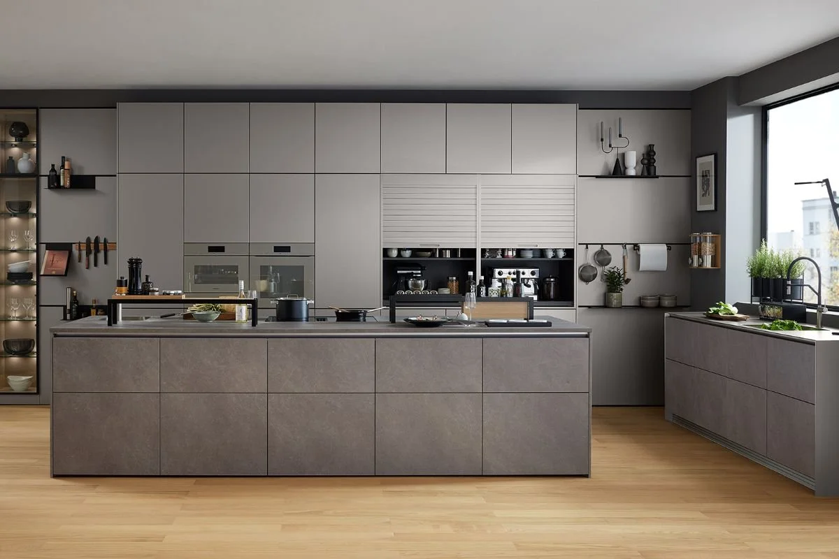 Modern kitchen with gray cabinetry and a large island, open shelving, and a window with a city view.