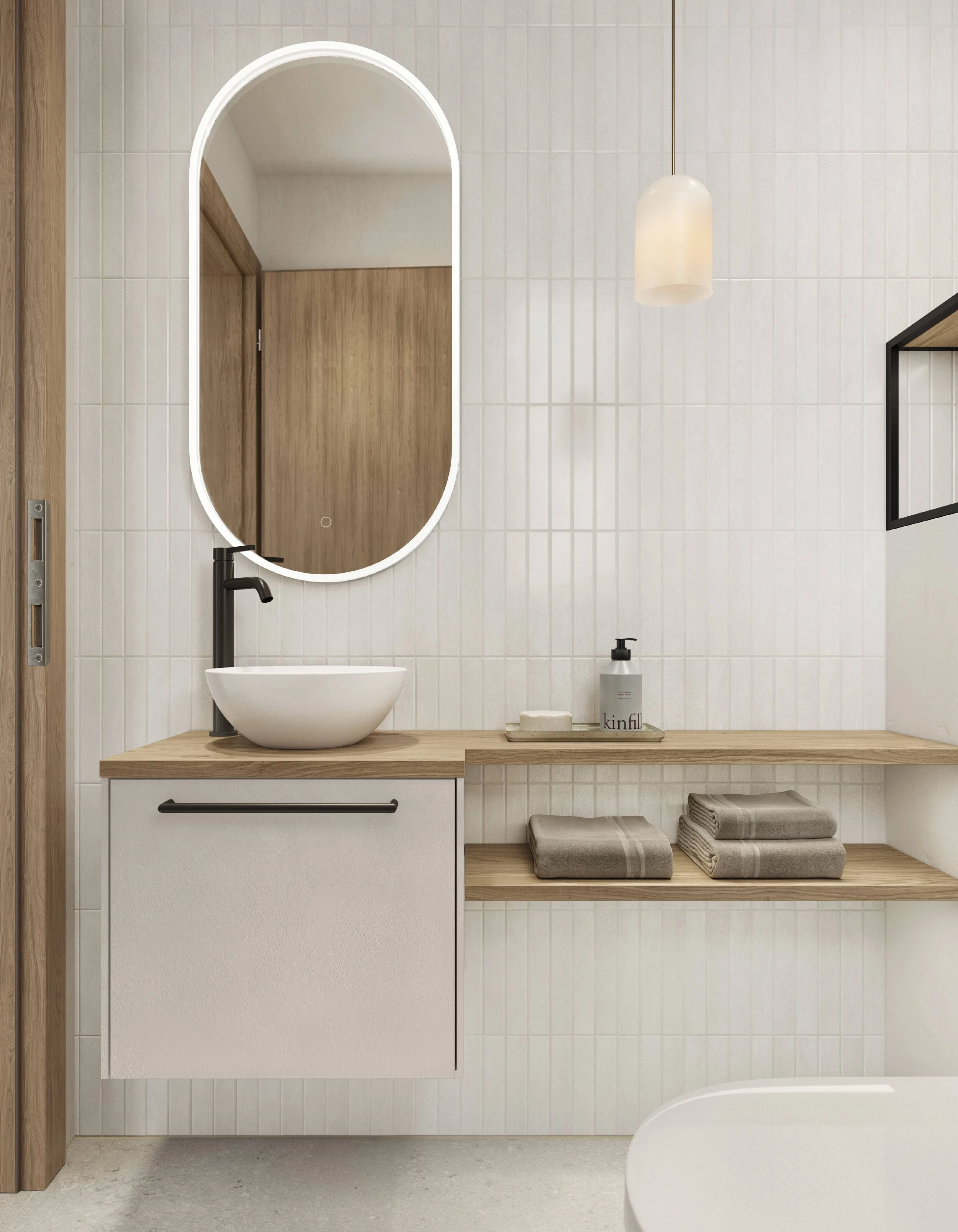 Minimalist bathroom with white textured tiled walls, a wooden vanity with a white vessel sink, a black faucet, a large oval mirror with LED lighting, a white pendant light, a soap dispenser, a tray, neatly folded towels on open wooden shelves, and pa