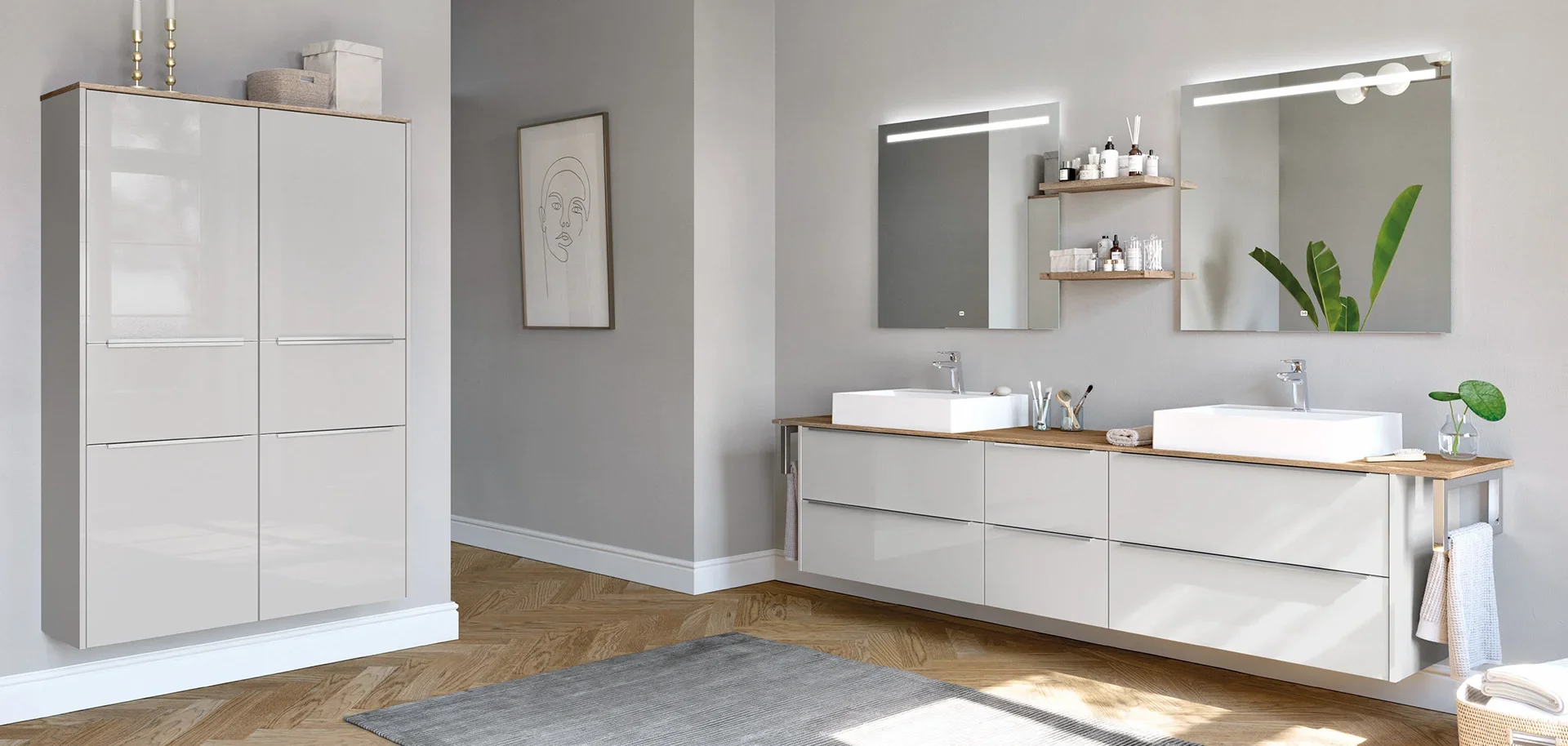 Modern bathroom with white double sinks, large mirrors with LED lights, wooden countertops, white cabinetry, shelves with toiletries, houseplant, framed artwork, and wooden flooring.