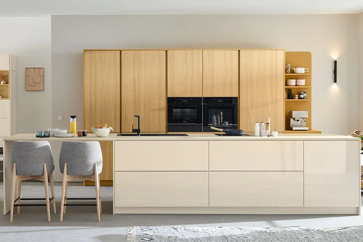 Modern kitchen with beige islands, wooden cabinetry, and built-in black oven and microwave.