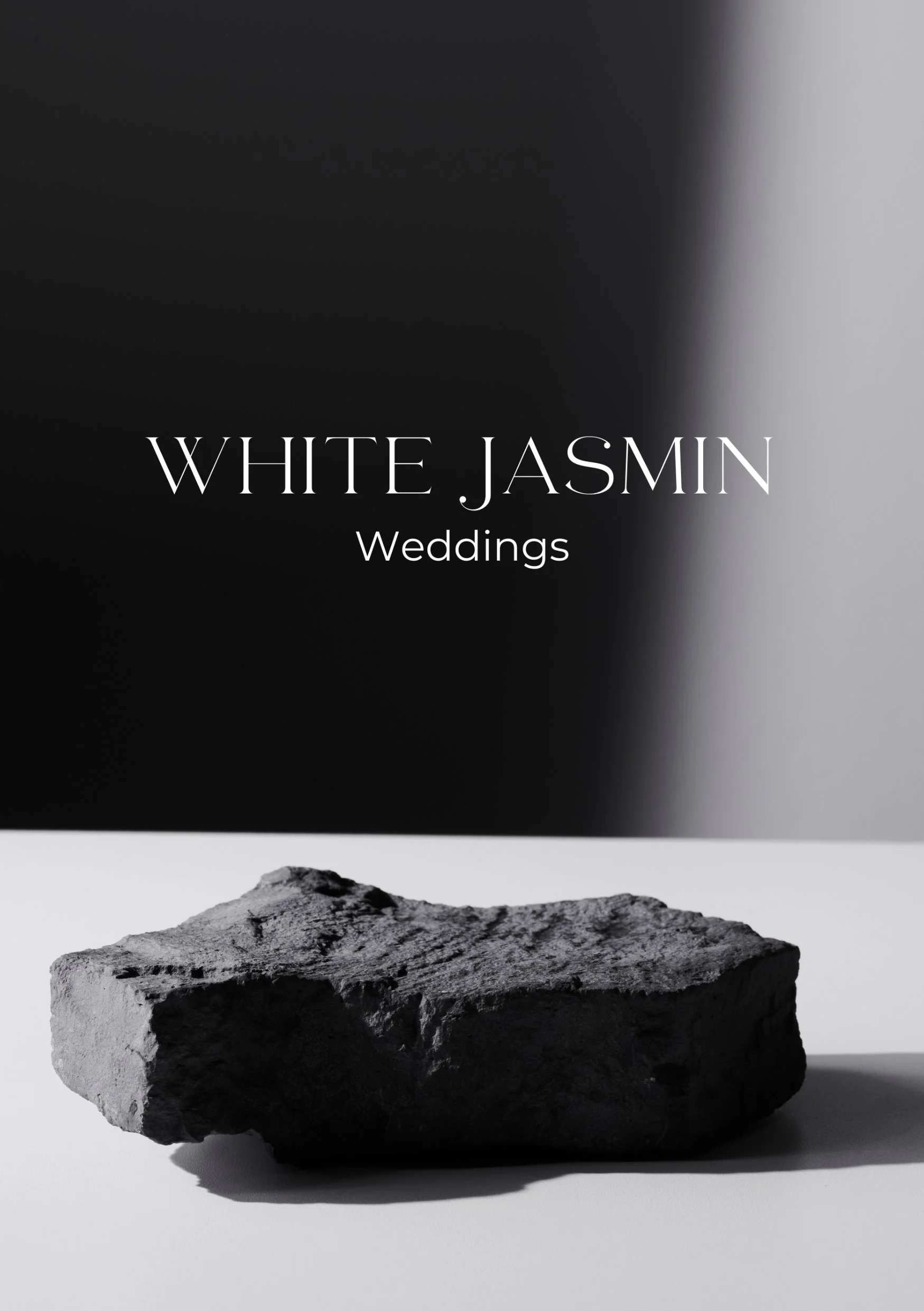 Schwarz-weiß Bild mit einem Stein im Vordergrund und schwarzem, grau und weißen Hintergrund, Text: 'WHITE JASMIN Weddings'.