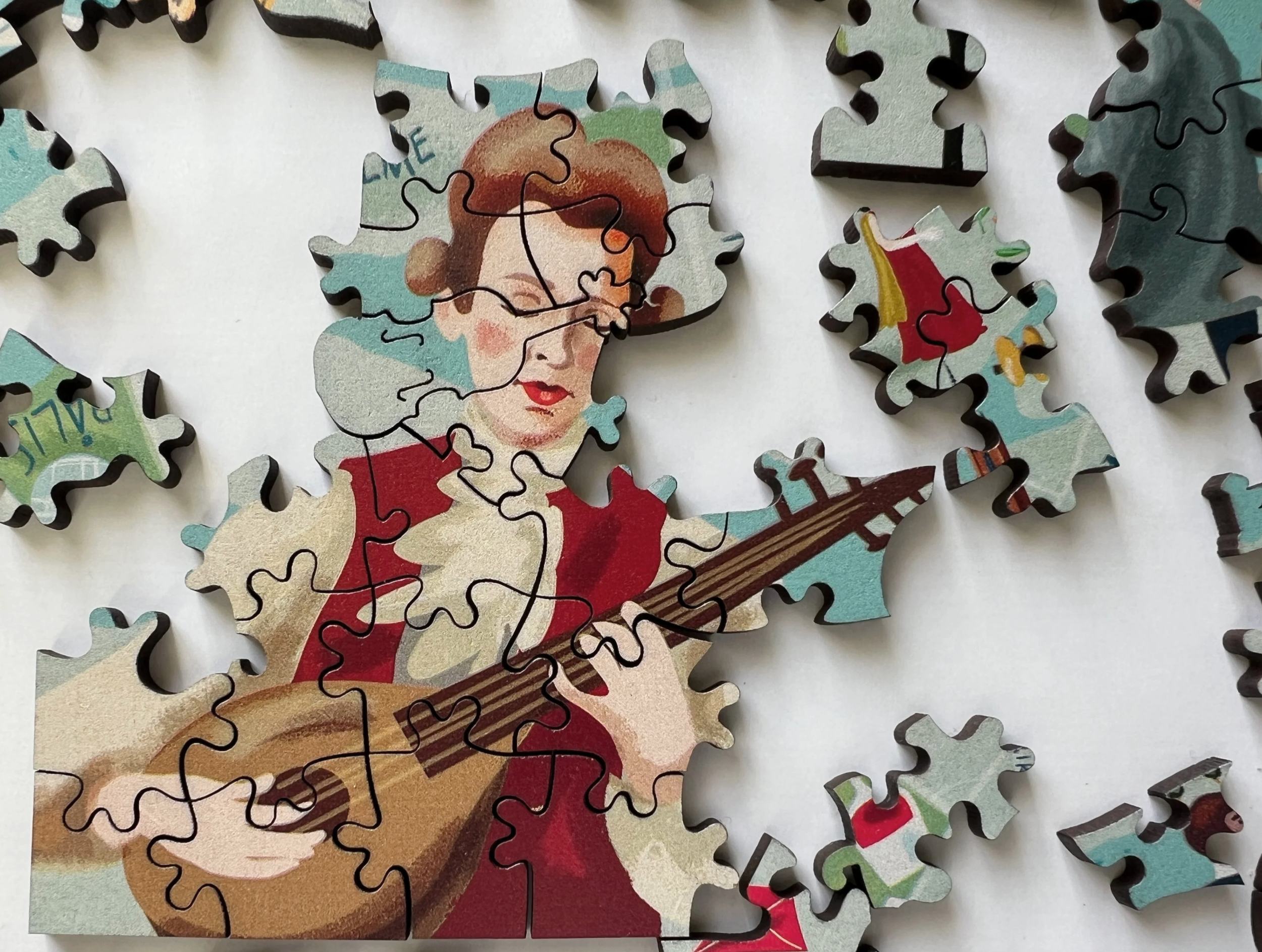 A partially assembled puzzle depicting a woman with red hair wearing red clothing, holding and playing a guitar