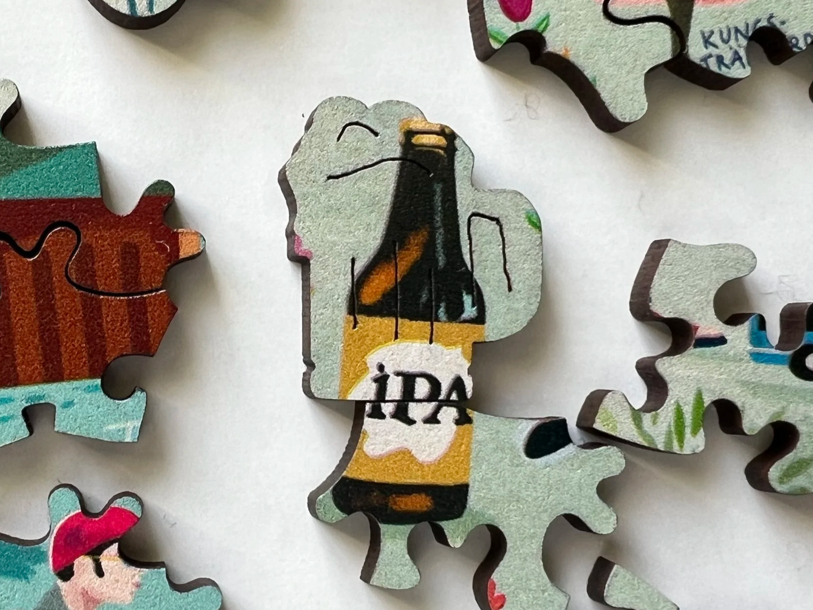 A puzzle piece depicting a cartoon-style image of a woman with gray hair and pink lips, holding a brown beer bottle with what appears to be the word 'IPA' on it.