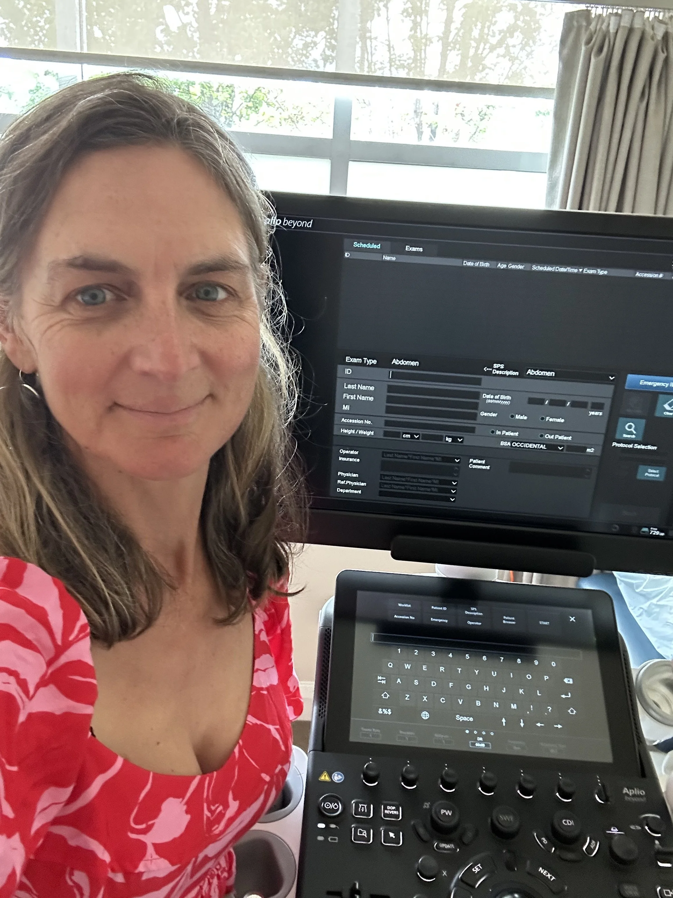 Image of Jane Wilkinson sitting at a desk with the sonography screen behind her.