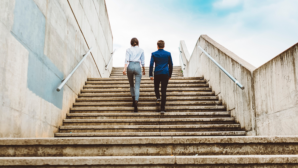 Two professionals walking up a concrete staircase