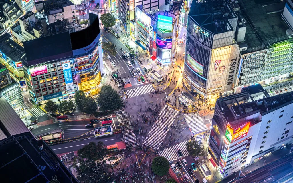 Shibuya city intersection, busy crosswalks, and moving vehicles, characteristic of a bustling urban area. Japanese city. Tokyo, Shinjuku, Ginza, Asakusa. Make Your Chopsticks