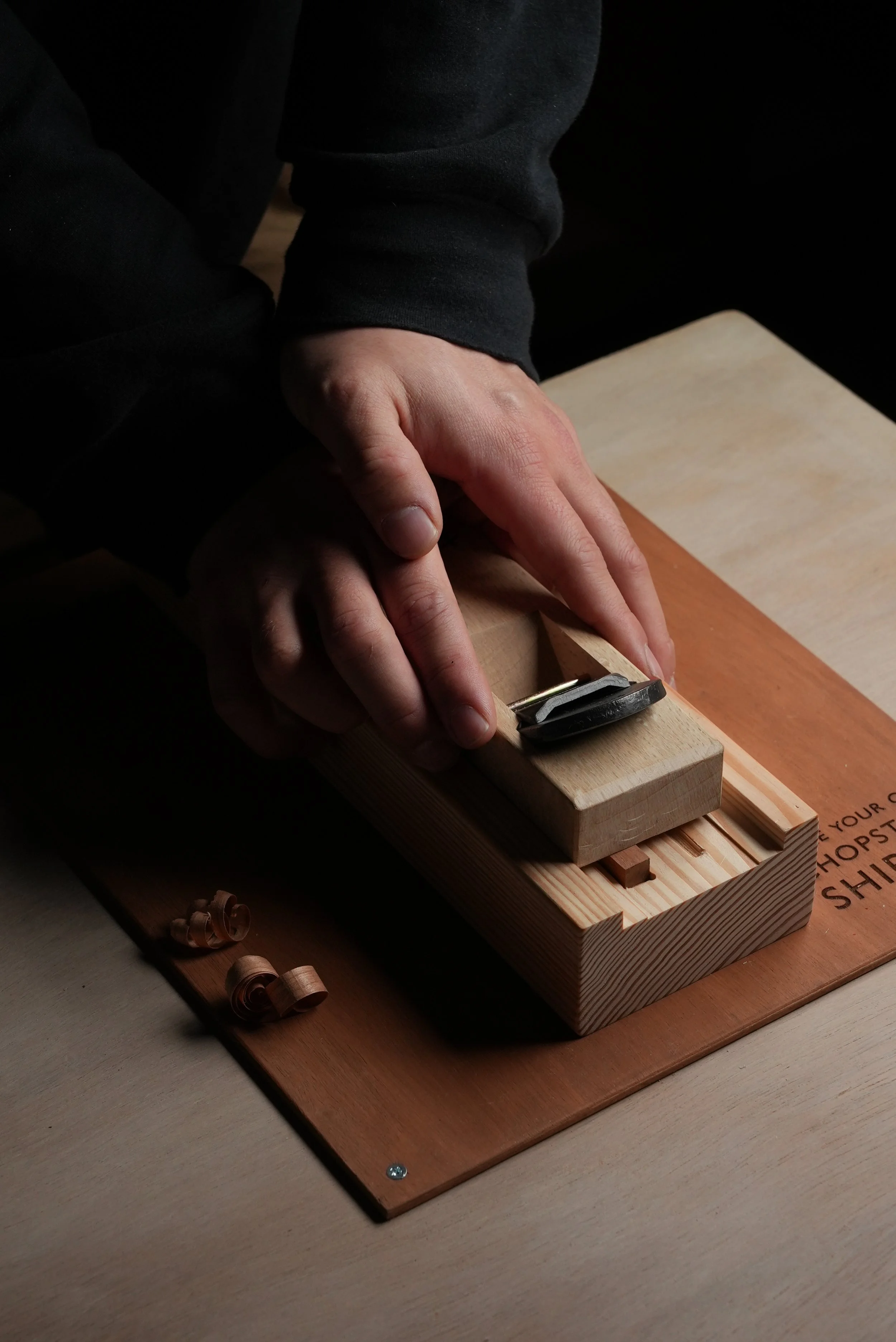 Person sanding a piece of wood with a hand plane on a woodworking project. Carving their own chopstick. Things to do in shibuya. Masterclass. Kanna, Pulling, teaching experience.