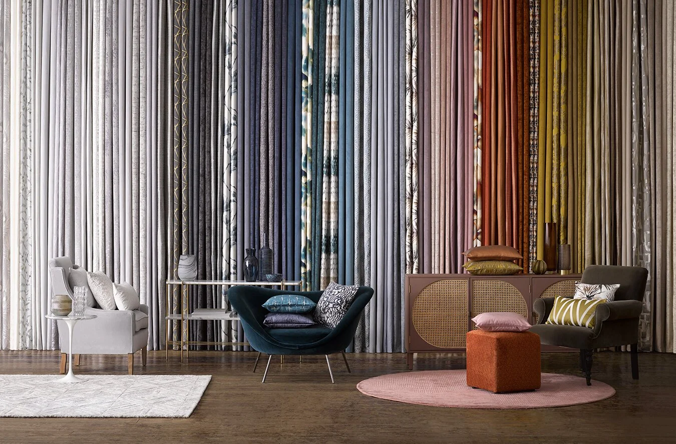 Interior living space with colorful patterned curtains, modern chairs, pillows, rugs, and decorative accessories.