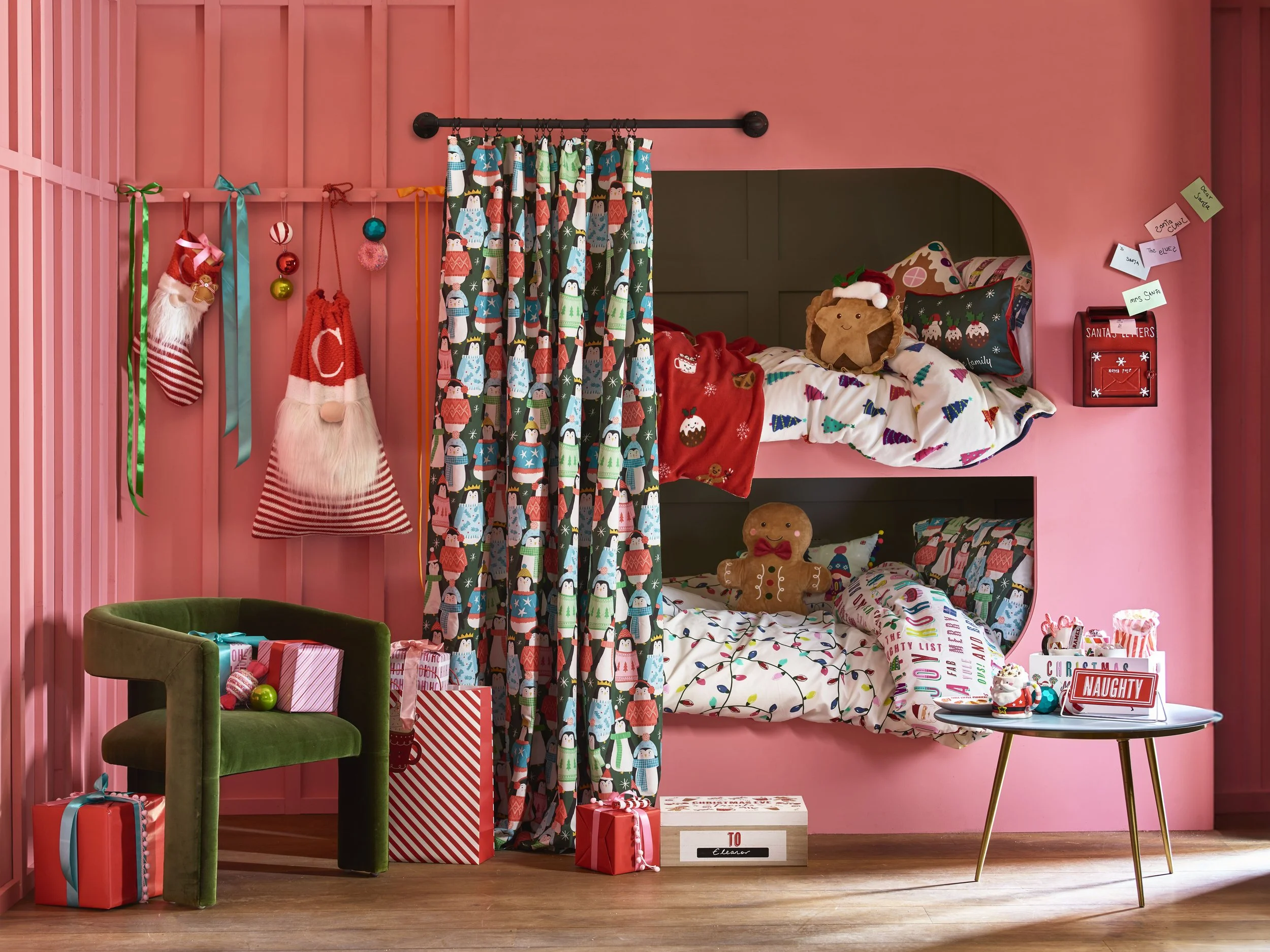 A cozy pink bedroom decorated for Christmas with a bunk bed, plush toys, wrapped presents, and holiday decorations.