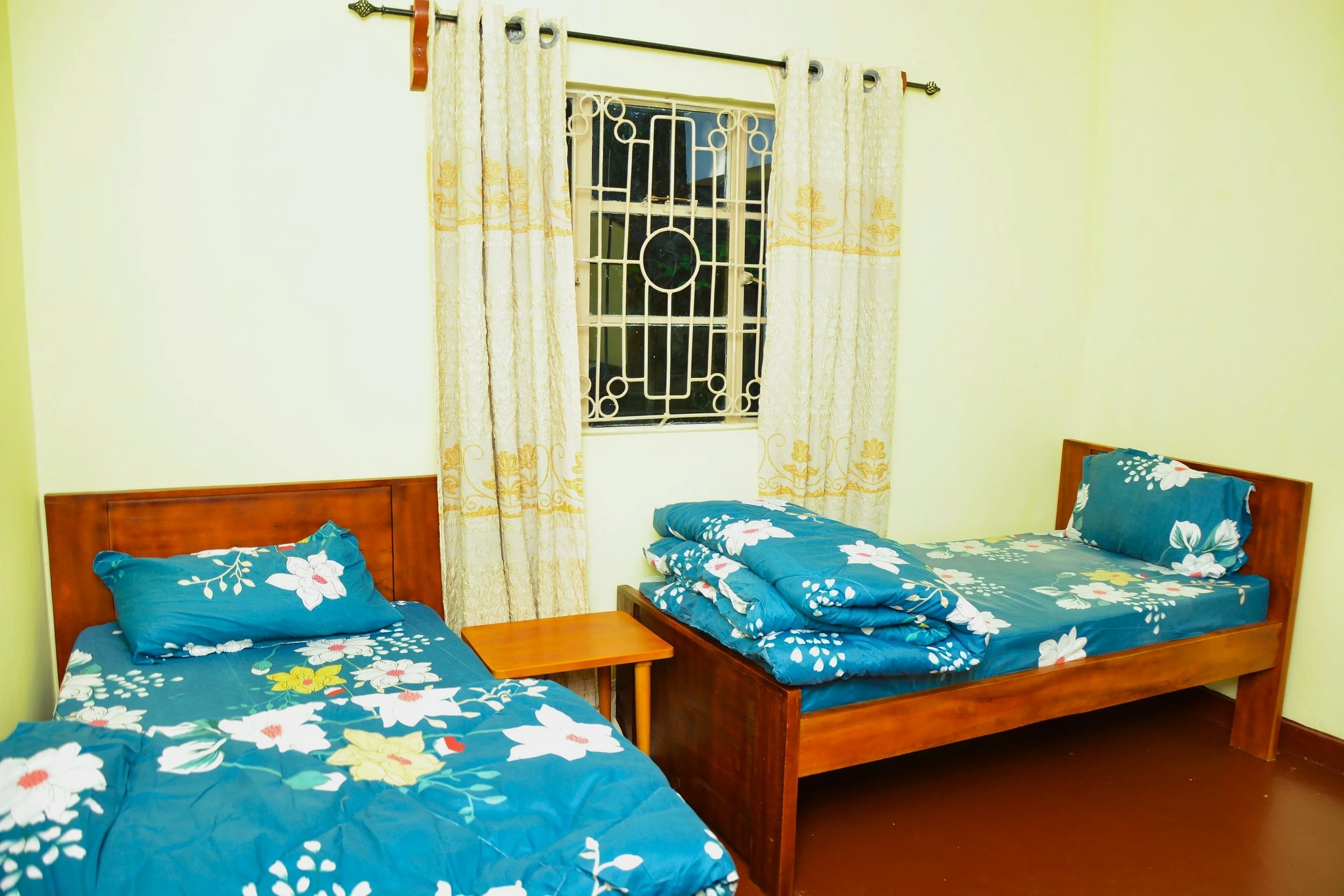 Modern wooden building with large glass window, set against a mountain landscape.