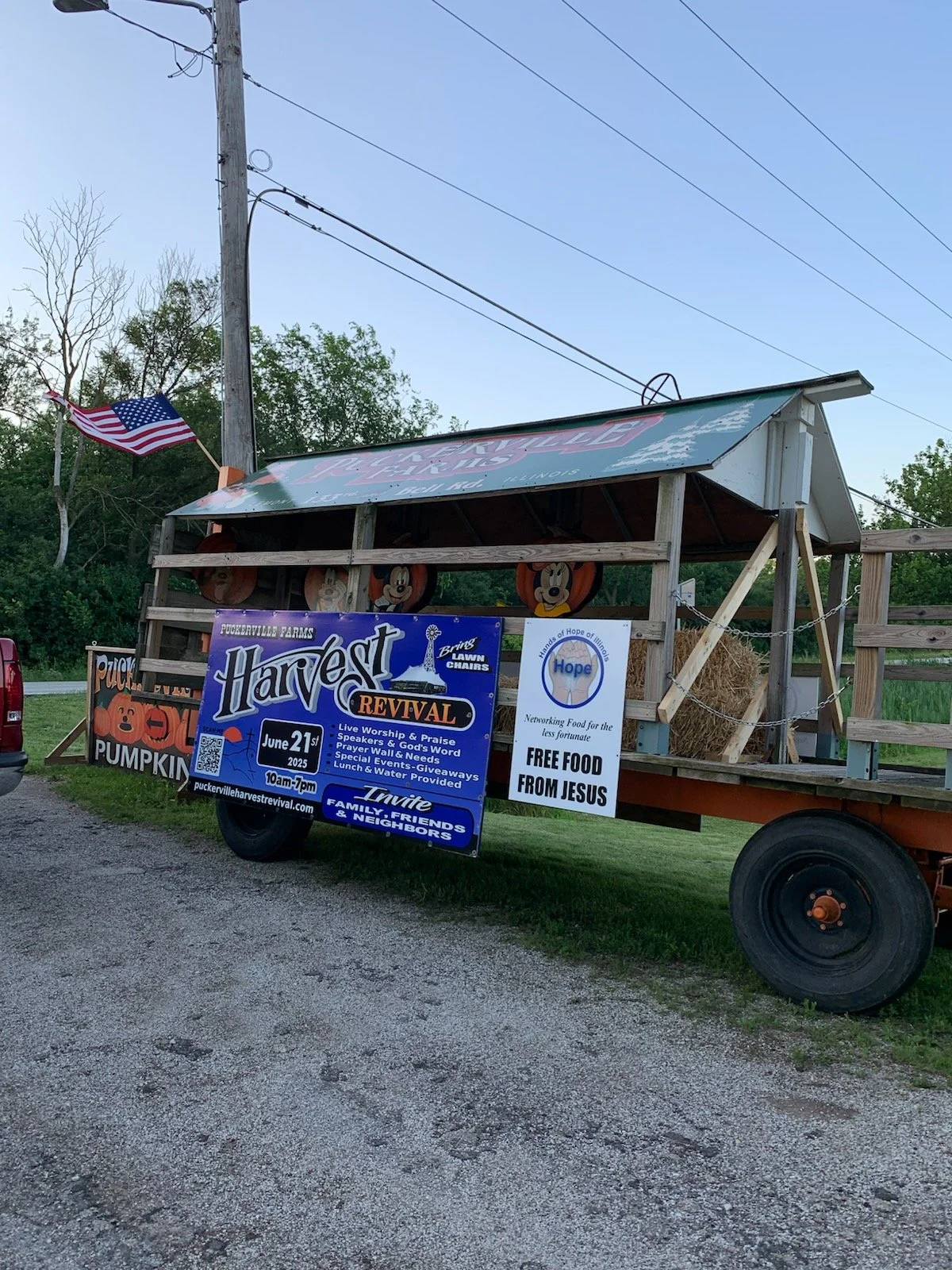 A farm wagon with signs advertising a harvest revival event.