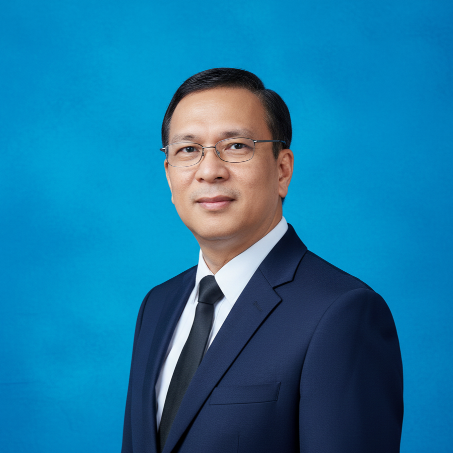 Professional portrait of a man wearing a navy suit, white shirt, black tie, and glasses against a blue background.