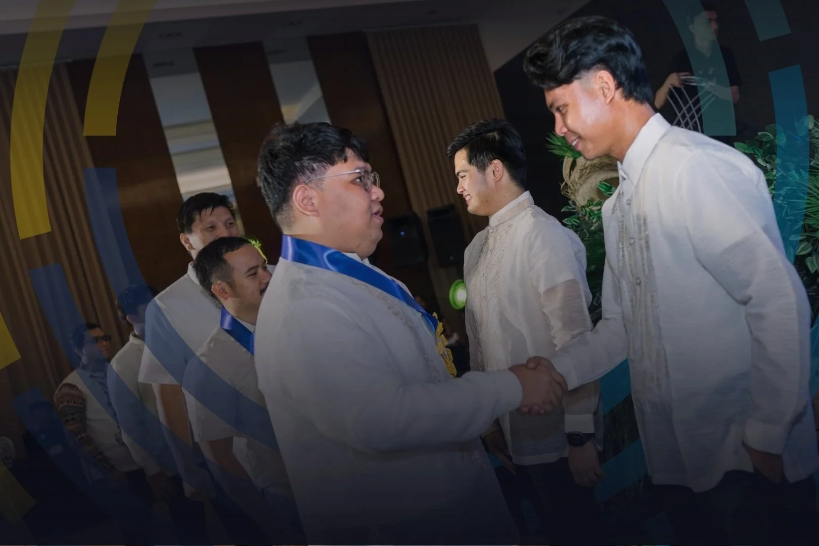 A group of men in traditional Filipino barong shirts engaged in a handshake, in a formal event setting.