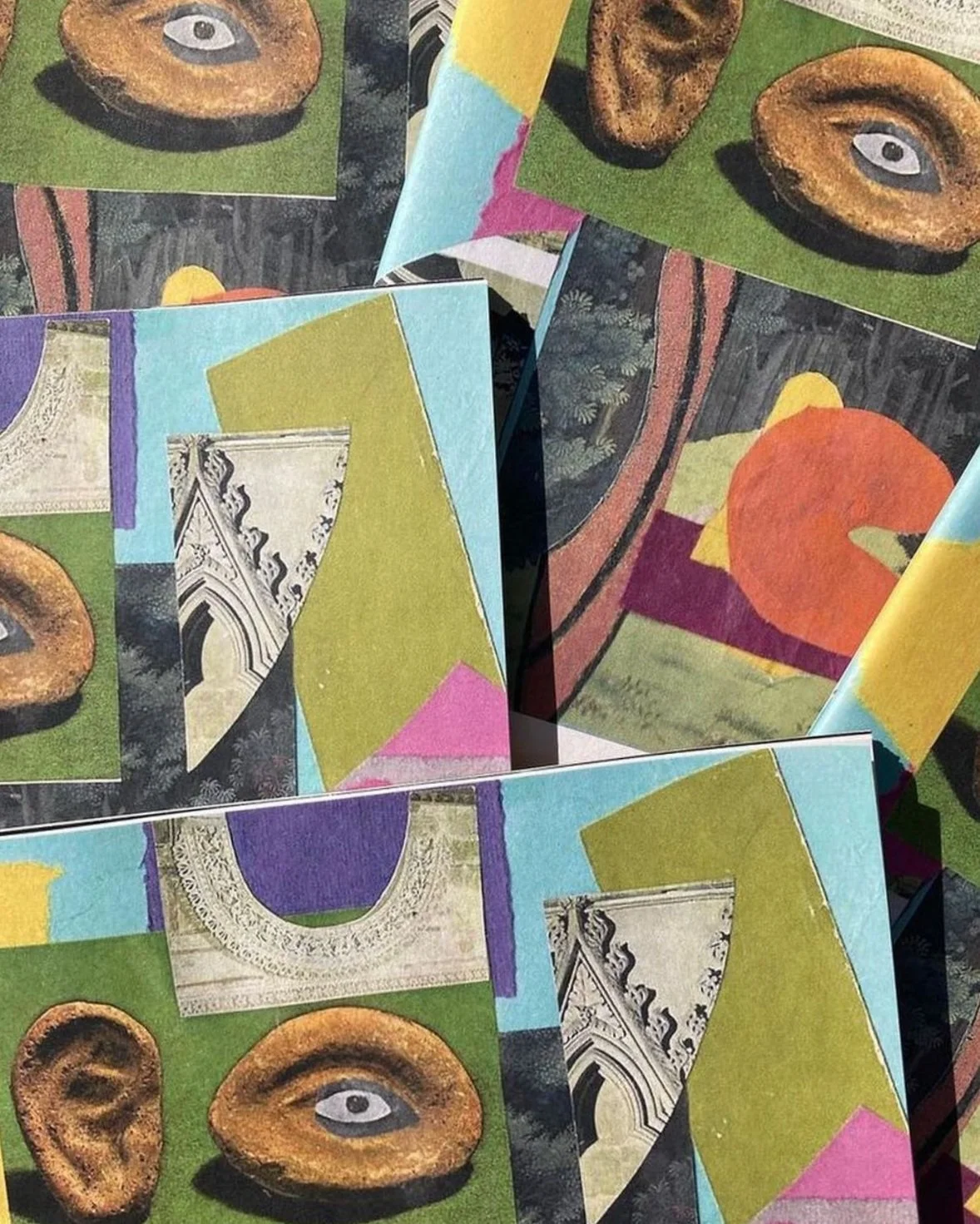 Multiple printed paper sheets featuring abstract artwork with images of historic architectural details, colorful geometric shapes, and artistic patterns.