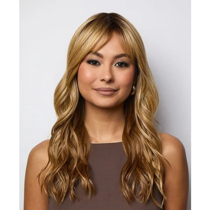 A young woman with long wavy blond hair wearing a sleeveless brown top, smiling slightly, against a neutral background.