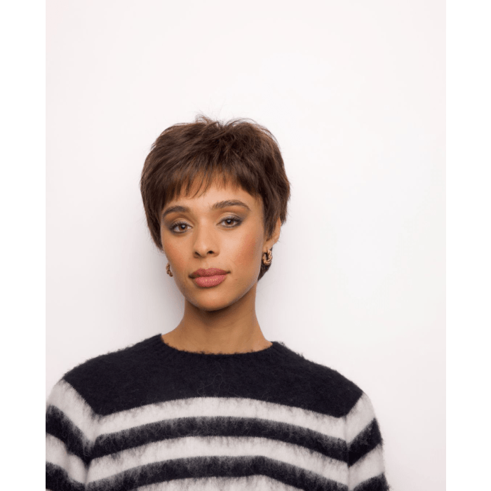 Young woman with short brown hair, wearing a black and white striped sweater, against a white background.