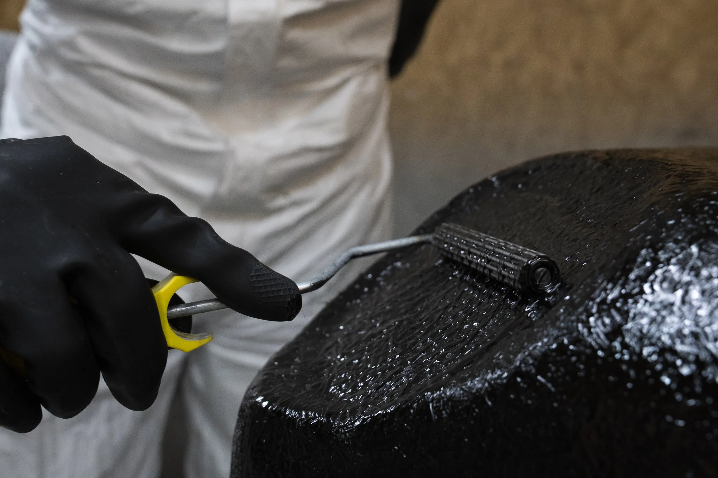 Rolling resin onto fibreglass to create a land rover interior trim.