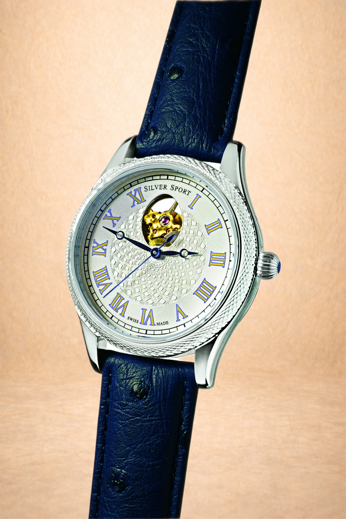 Close-up of a silver wristwatch with a blue leather strap, featuring a detailed textured dial, Roman numeral hour markers, and an open heart mechanism showing the movement inside.