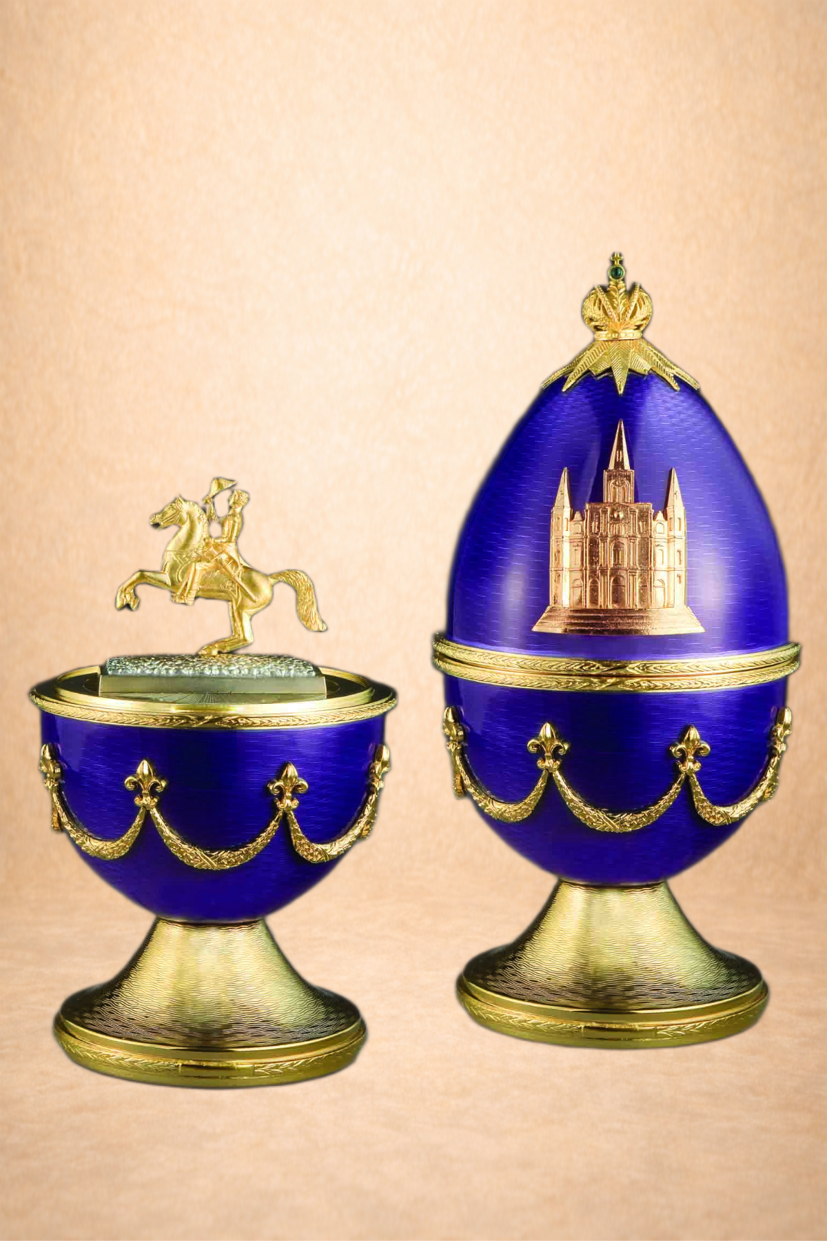 Two decorative blue and gold containers, one with a miniature figure of a crowned horse and rider on top, and the other with a castle design and a gold crown at the top. The containers are set against a peach-colored background.