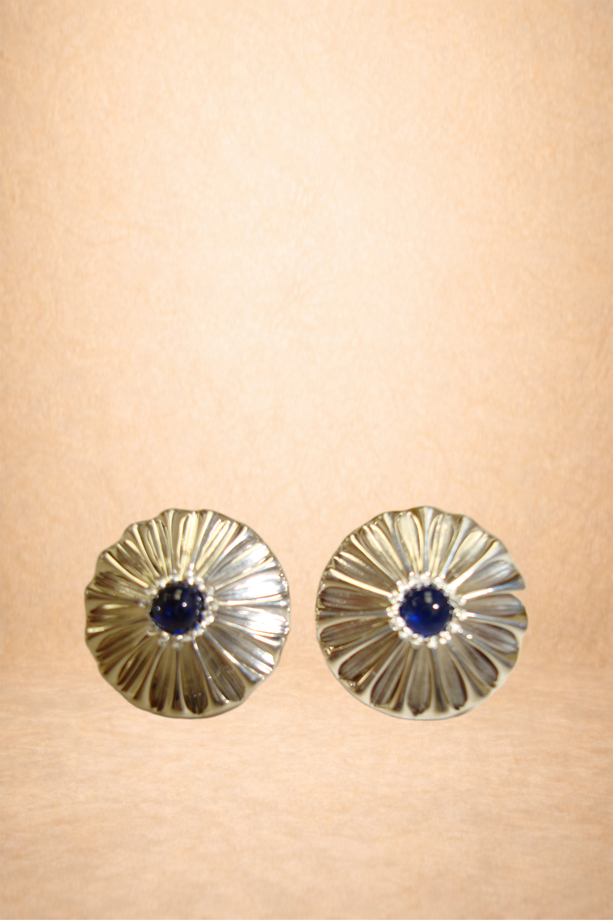 Pair of silver earrings with dark blue center stones, flower-shaped design