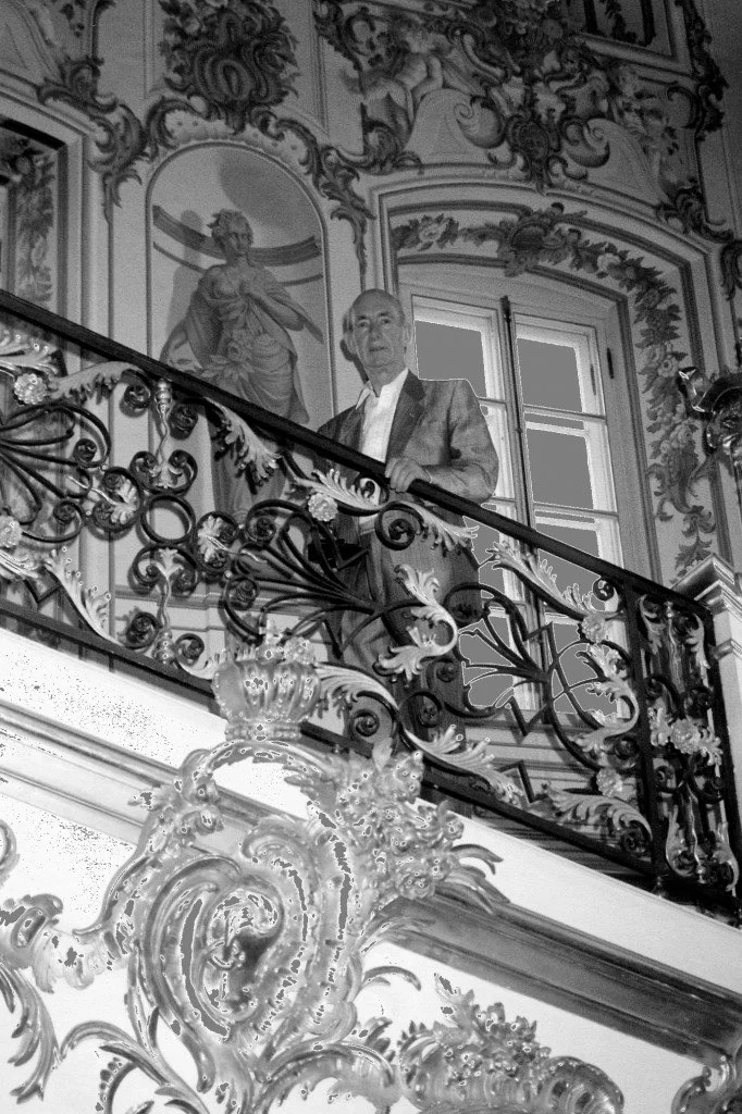 Theo Fabergé standing on an ornate staircase reflecting the artistic heritage of the Fabergé family legacy.