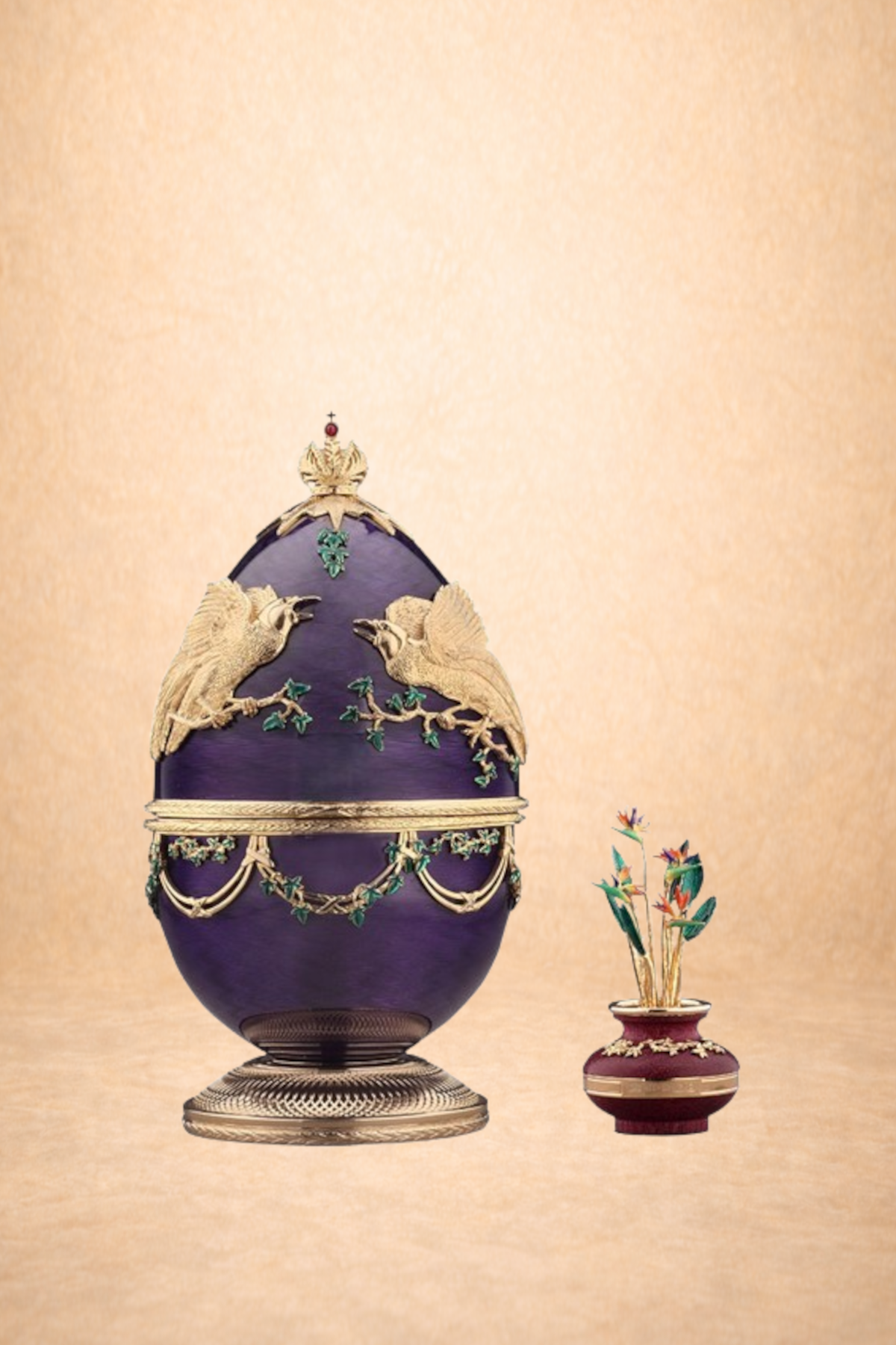 A decorative purple urn with gold accents and two flying bird sculptures, and a small matching vase with flowers beside it.