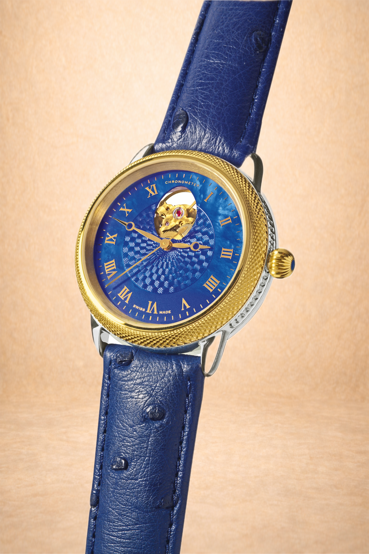 A luxury wristwatch with a blue watch face, gold bezel, and blue leather strap.
