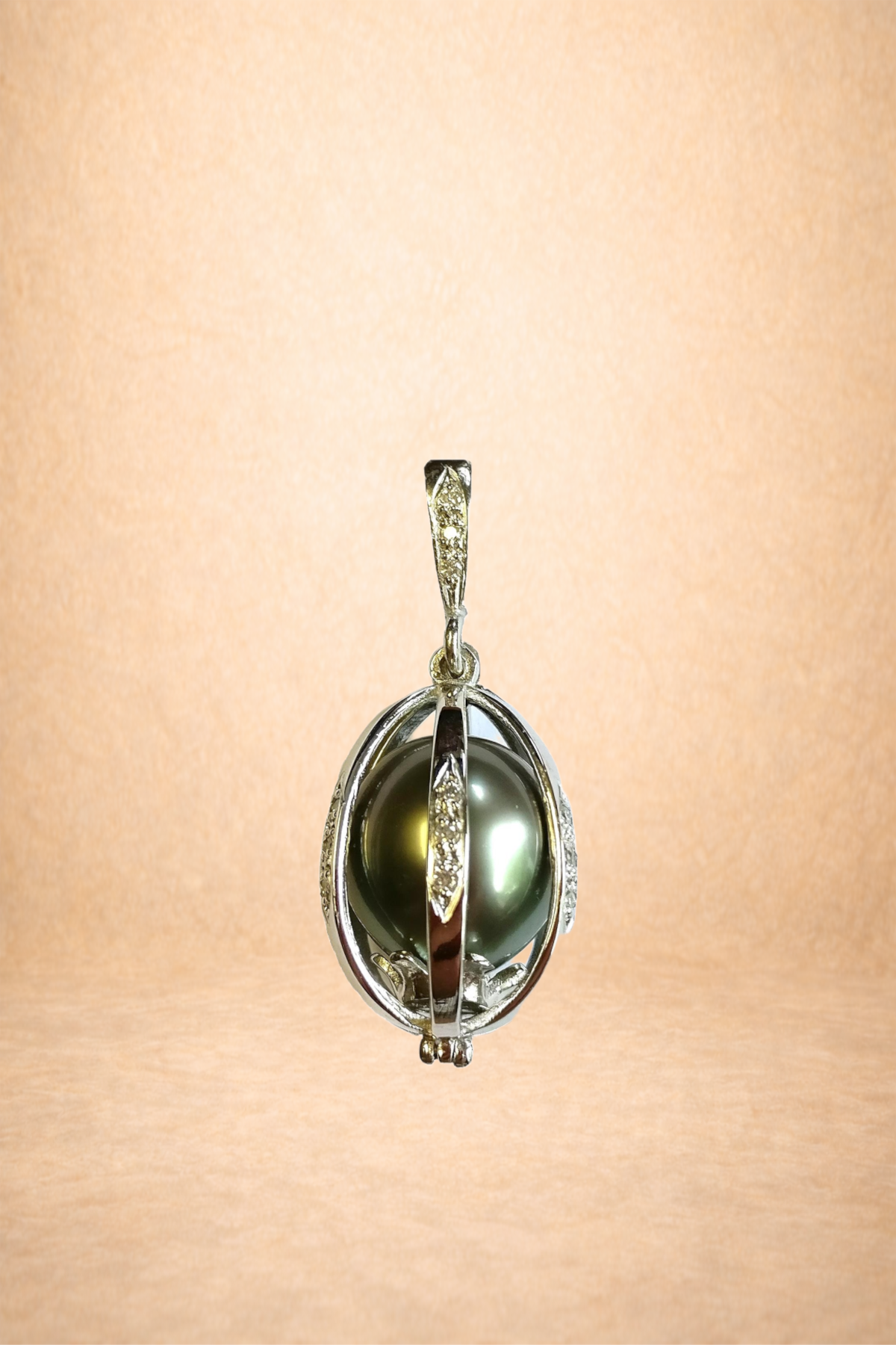 A silver pendant with a large, dark green pearl encased in a decorative silver setting.