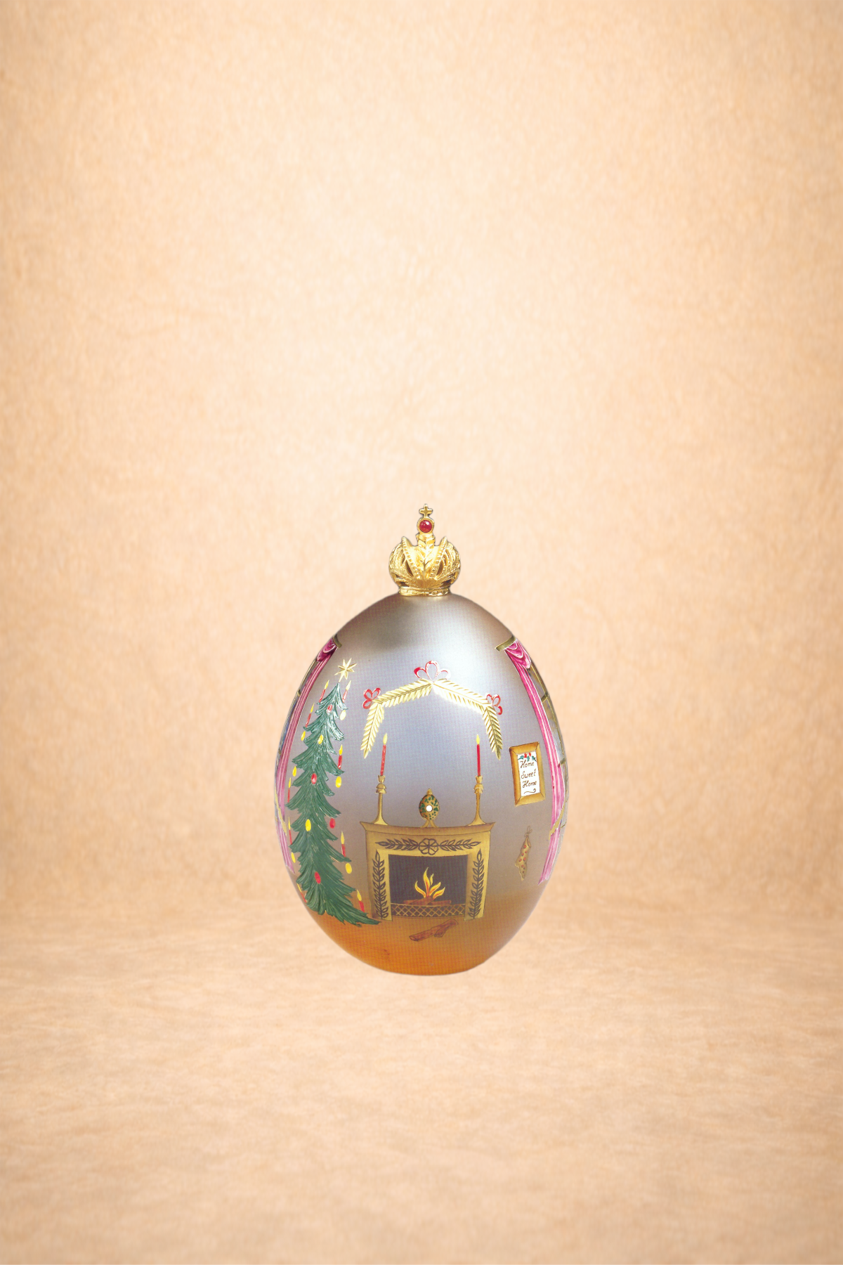 Decorative Christmas ornament with a painted scene of a fireplace, Christmas tree, and coat hanging on a pink wall, topped with a gold crown