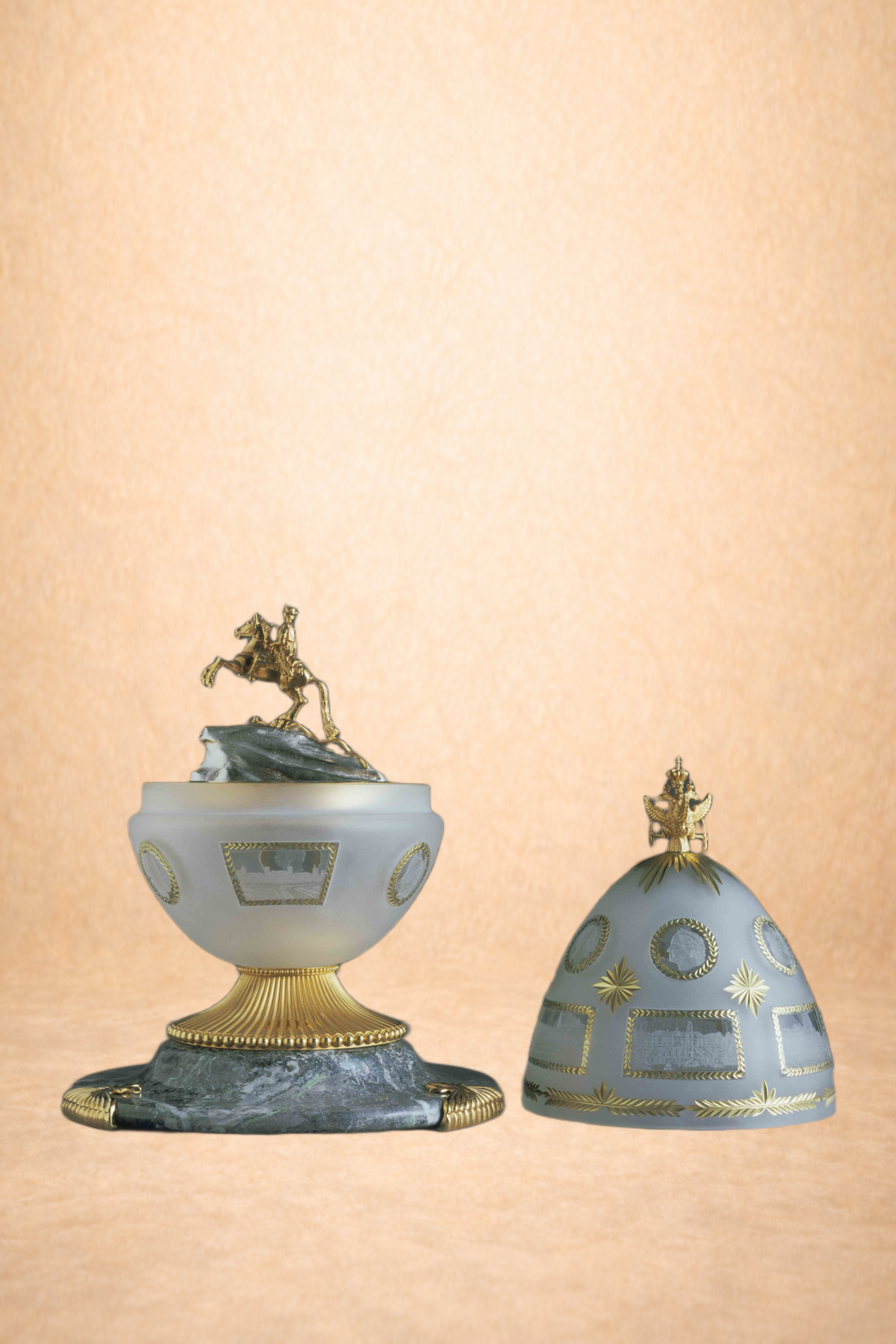 Decorative porcelain and gold items, including a piece with a gold horse figurine on top and a porcelain dome with gold accents, set against a light beige background.