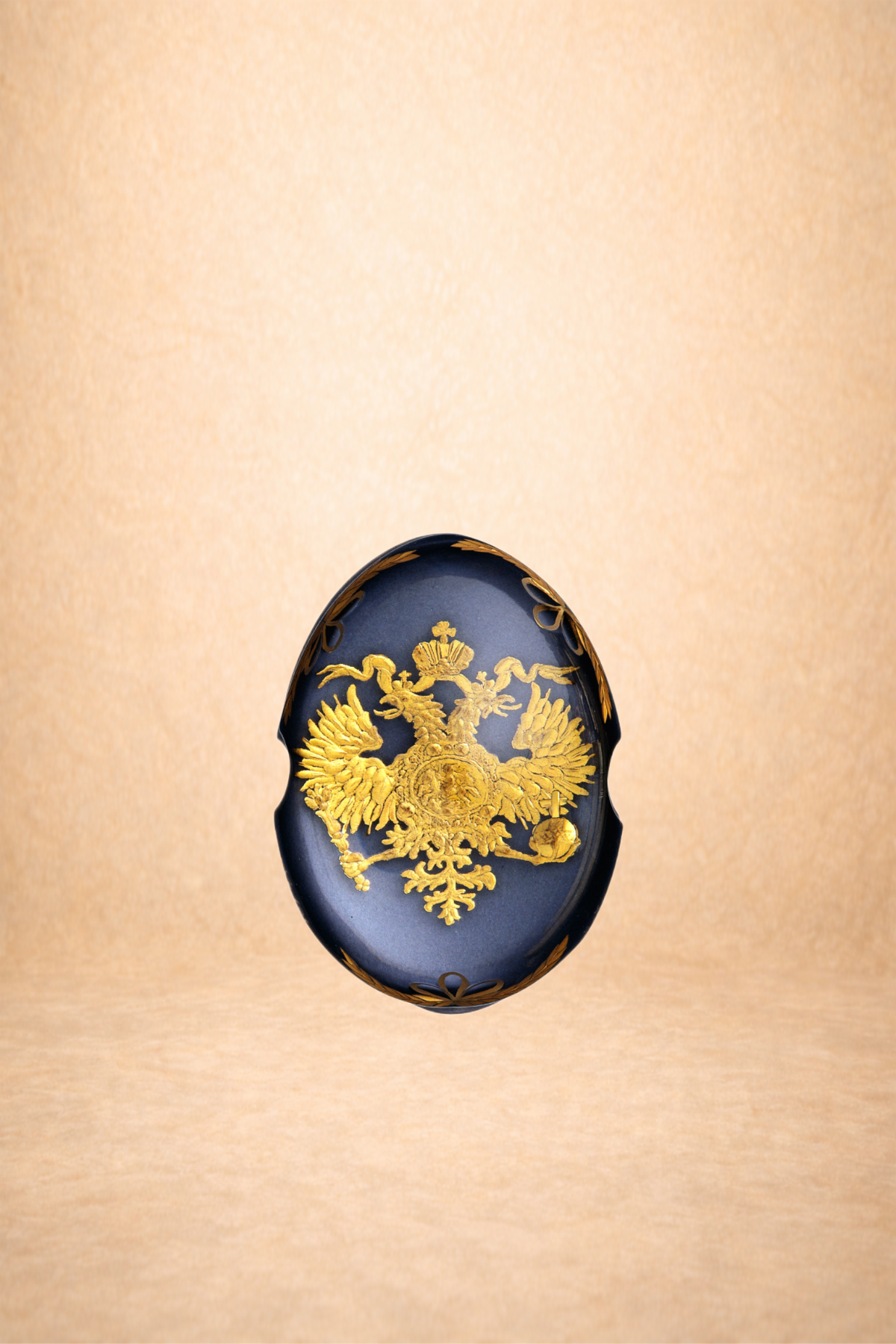 A black egg-shaped object with a gold double-headed eagle emblem on it, positioned against a beige background.