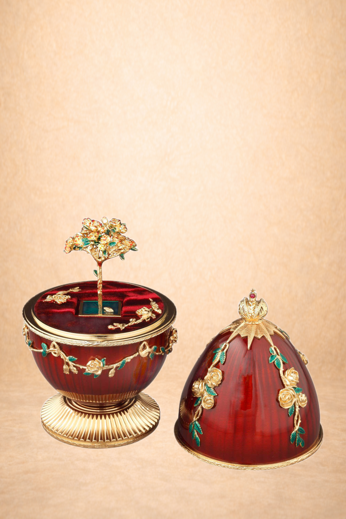 Two ornate decorative objects with a deep red base color, gold accents, and floral embellishments. The left object is a rounded container with a lid topped by a tree-like ornament, and the right object is a large egg-shaped piece, both displayed on a beige background.