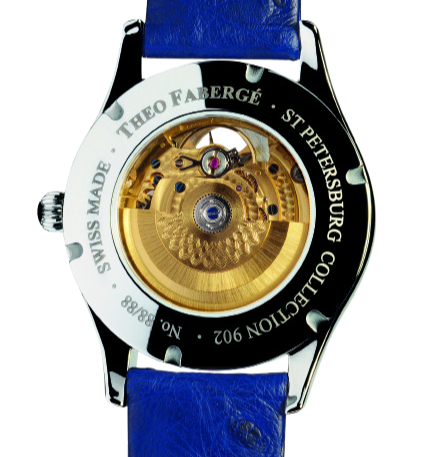 Back of a Theo Faberge watch with visible gold inner mechanism and a blue leather strap.