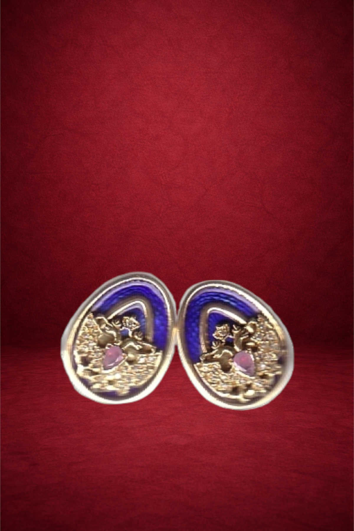 Pair of decorative earrings with pink and purple elements, resting on a red surface.